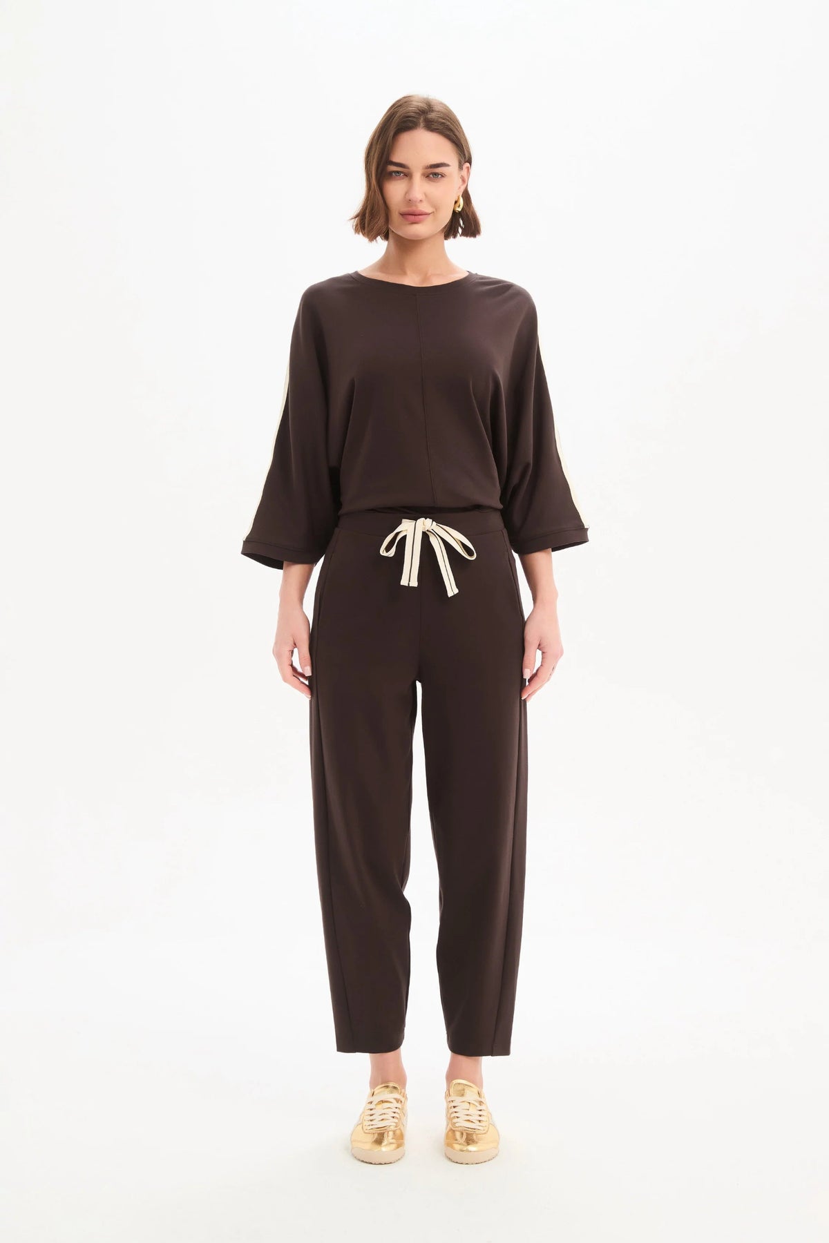 Woman wearing a brown outfit with a white background