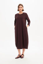 Woman wearing a burgundy dress on a white background