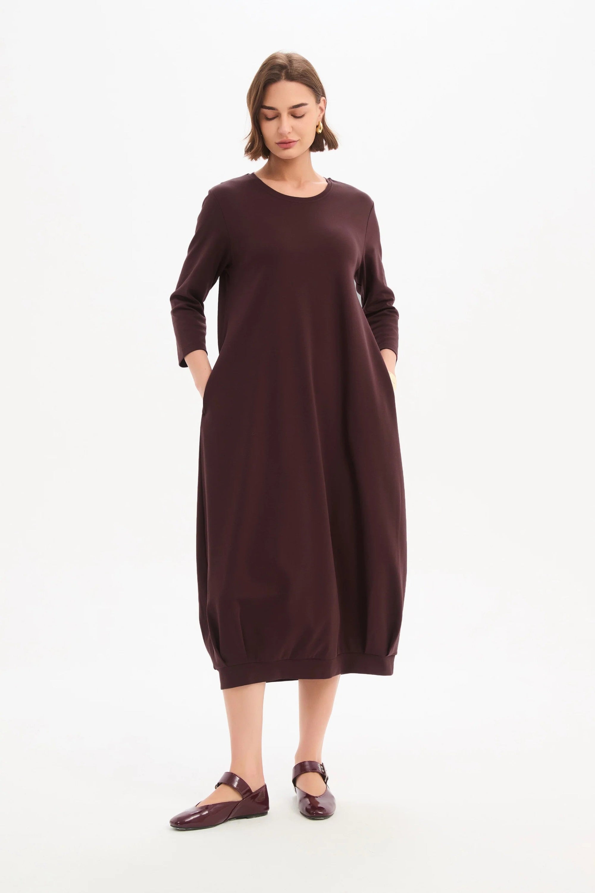 Woman wearing a burgundy dress on a white background