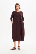 Woman wearing a burgundy dress on a white background