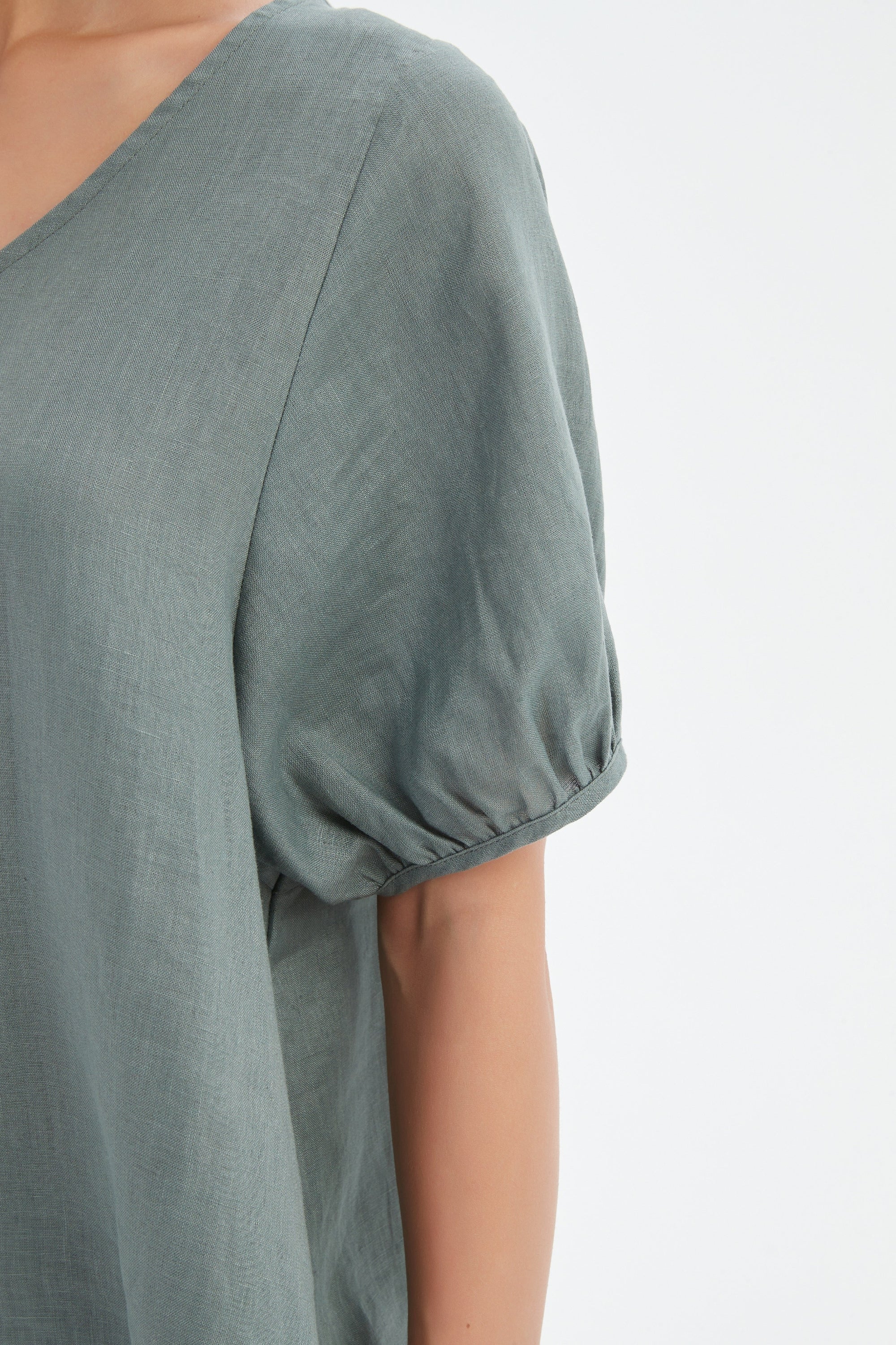 bishop sleeve v neck top in petrol worn by model close up