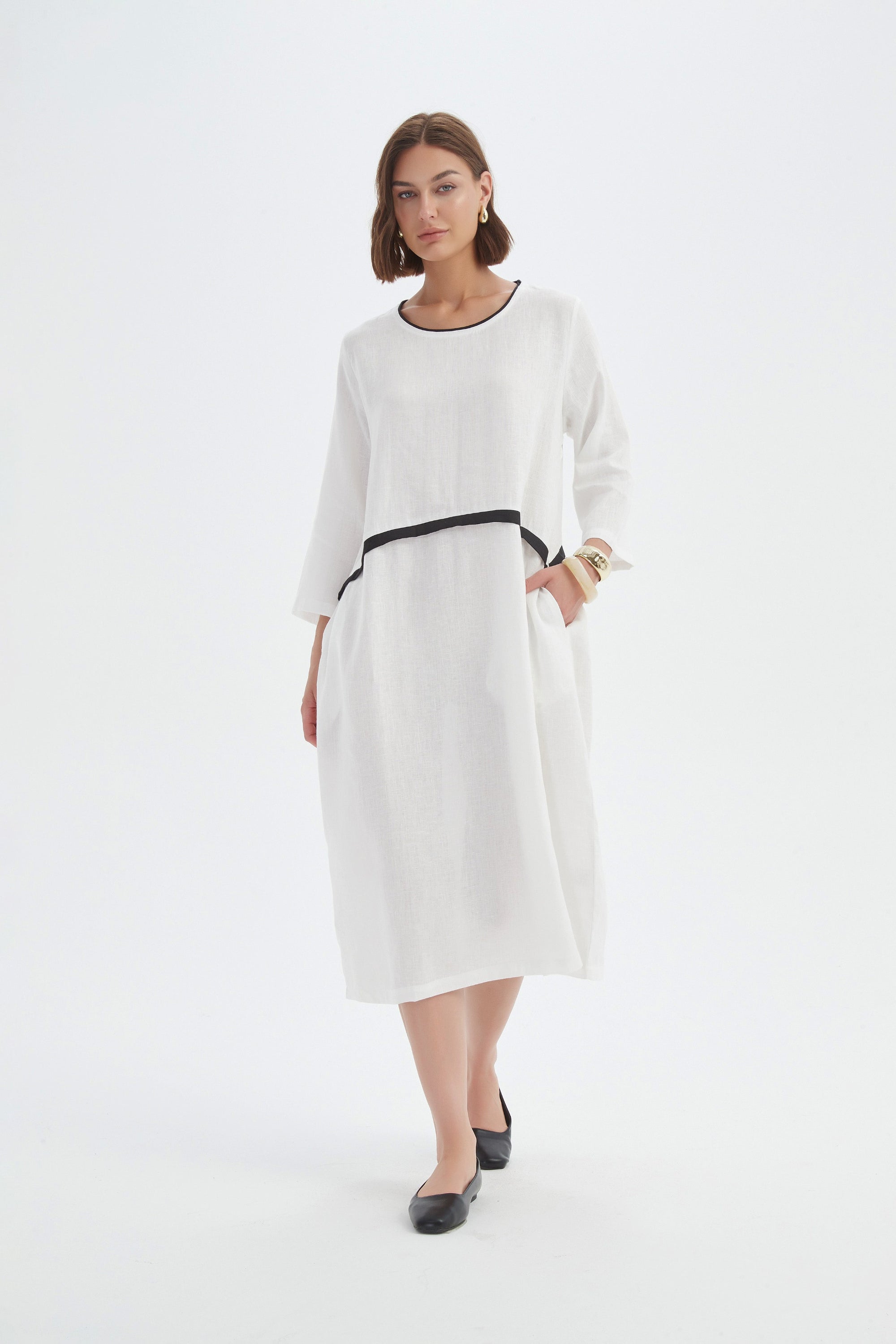 cream midi dress with black contrast worn by model 