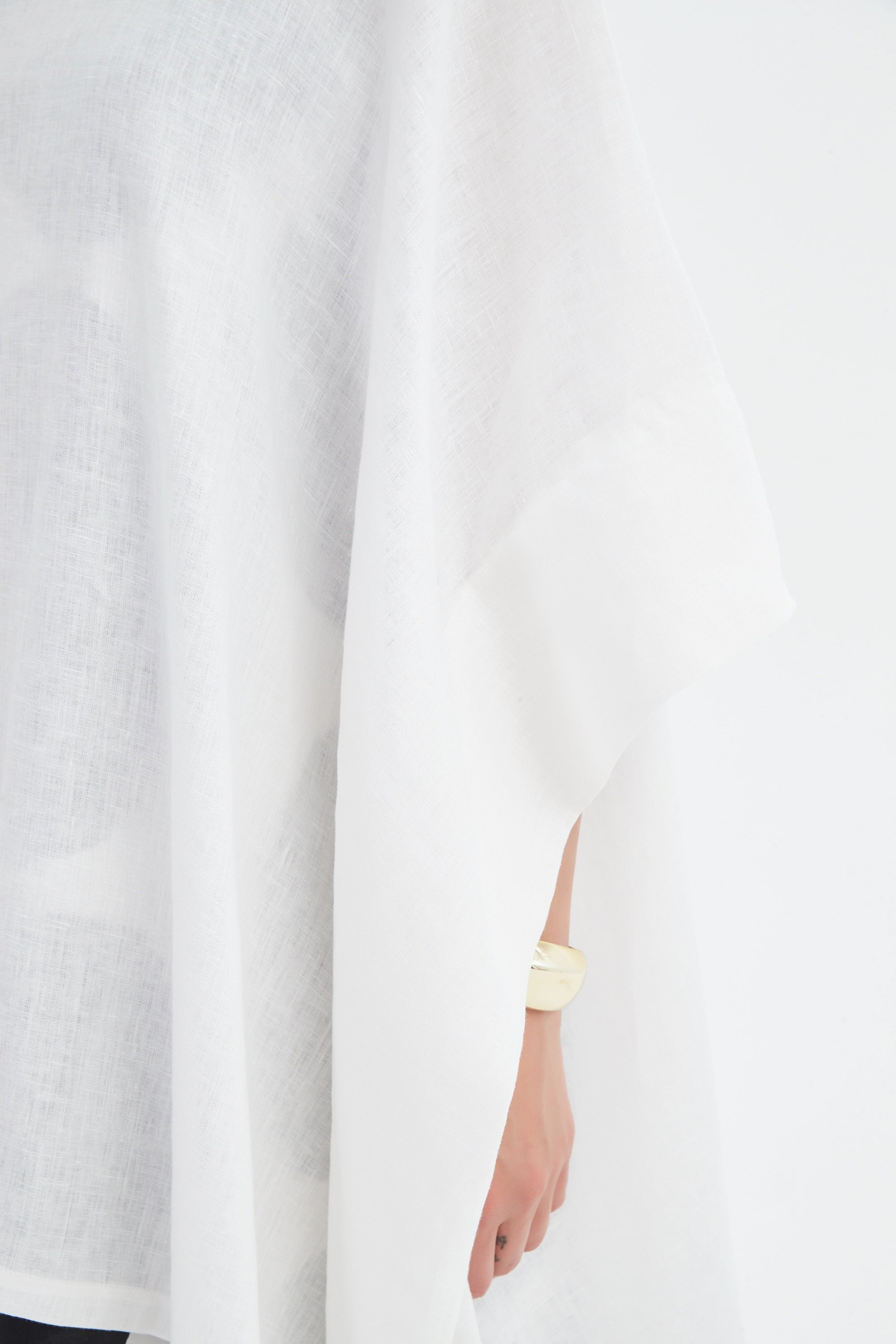 flowy waterfall poncho in white worn by model close up