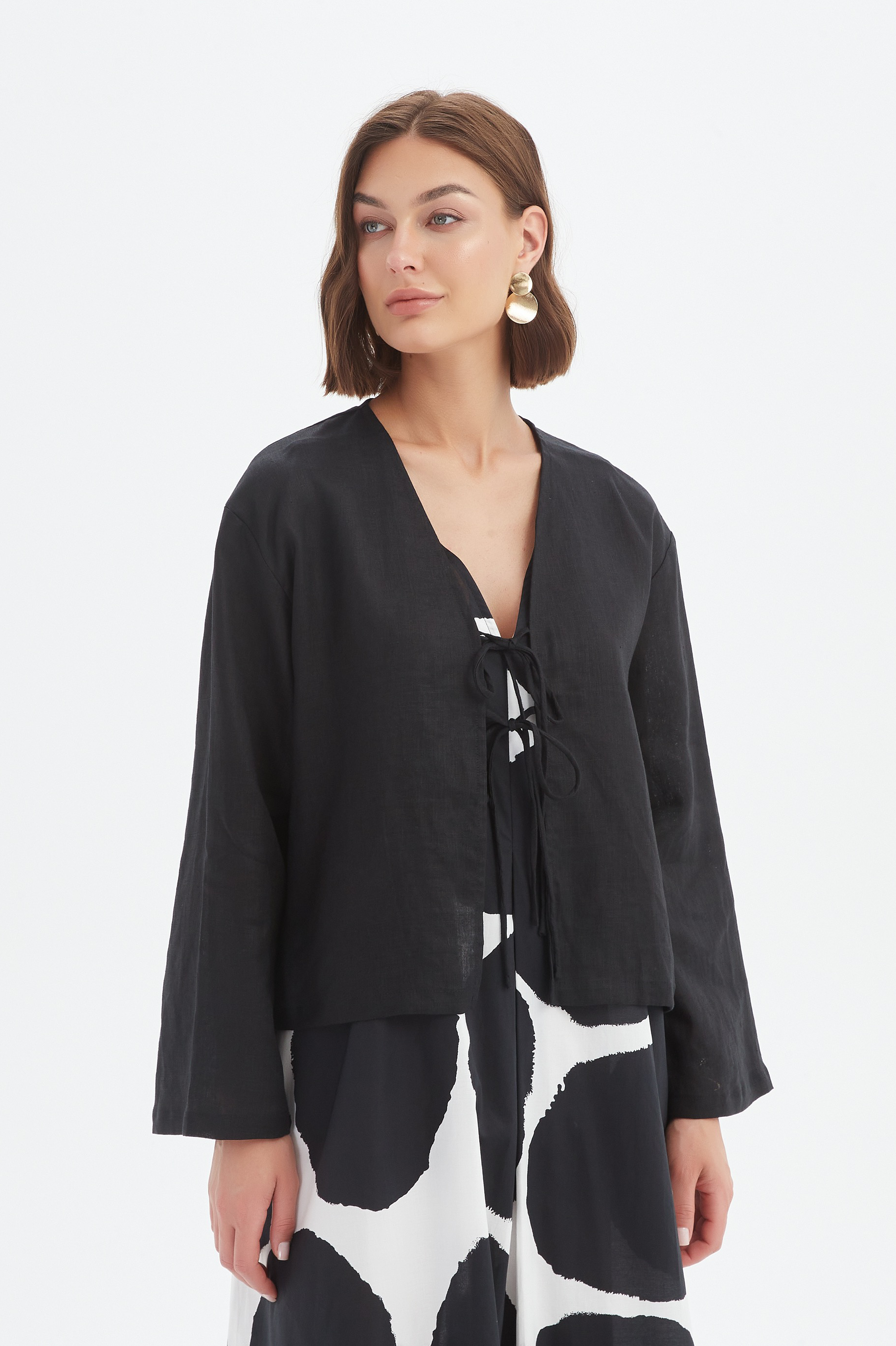 black long sleeve tie front top in black with print dress worn by model 