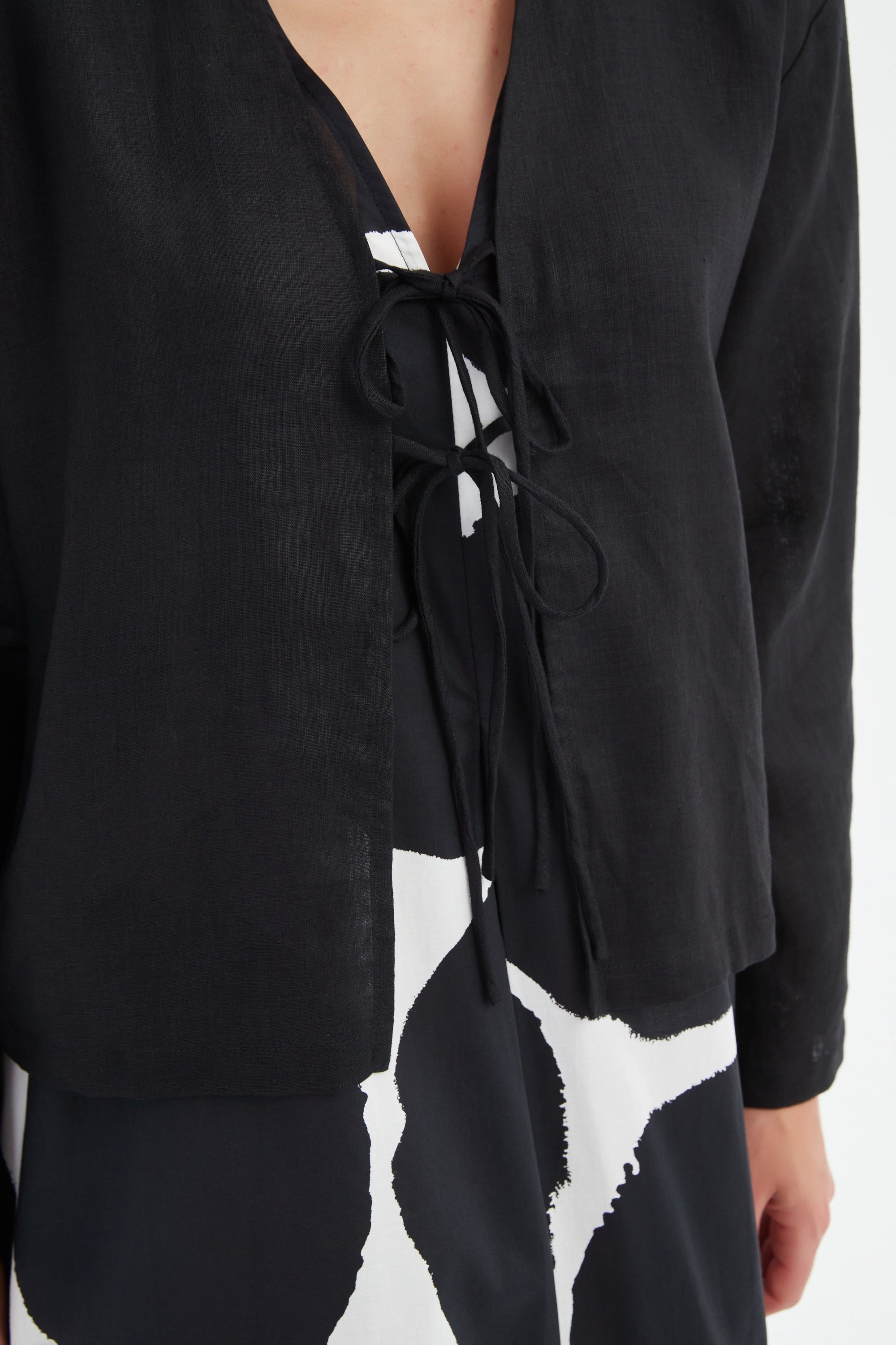 black long sleeve tie front top in black with print dress worn by model close up
