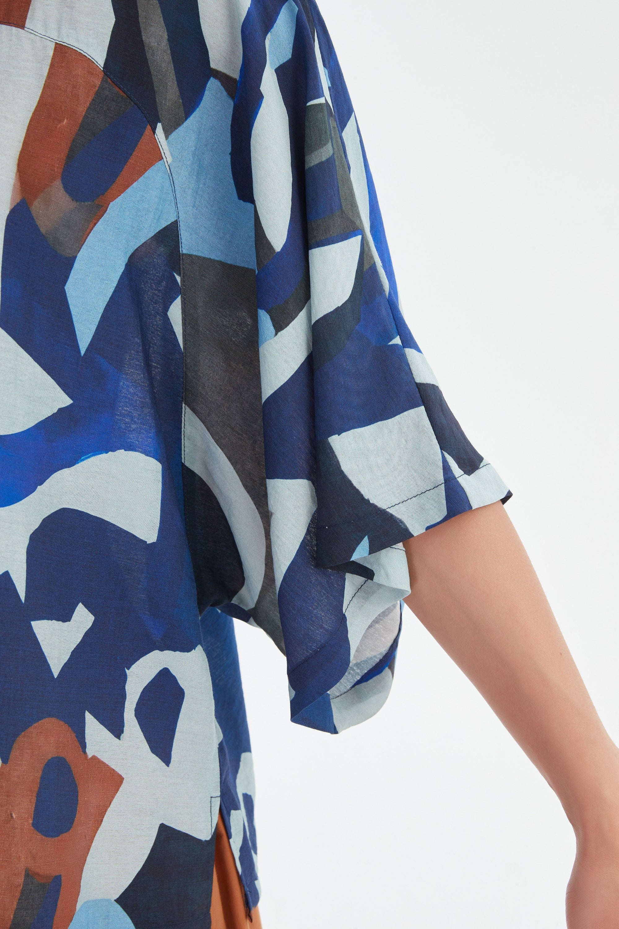blue abstract patterned top sleeve detail worn by model 