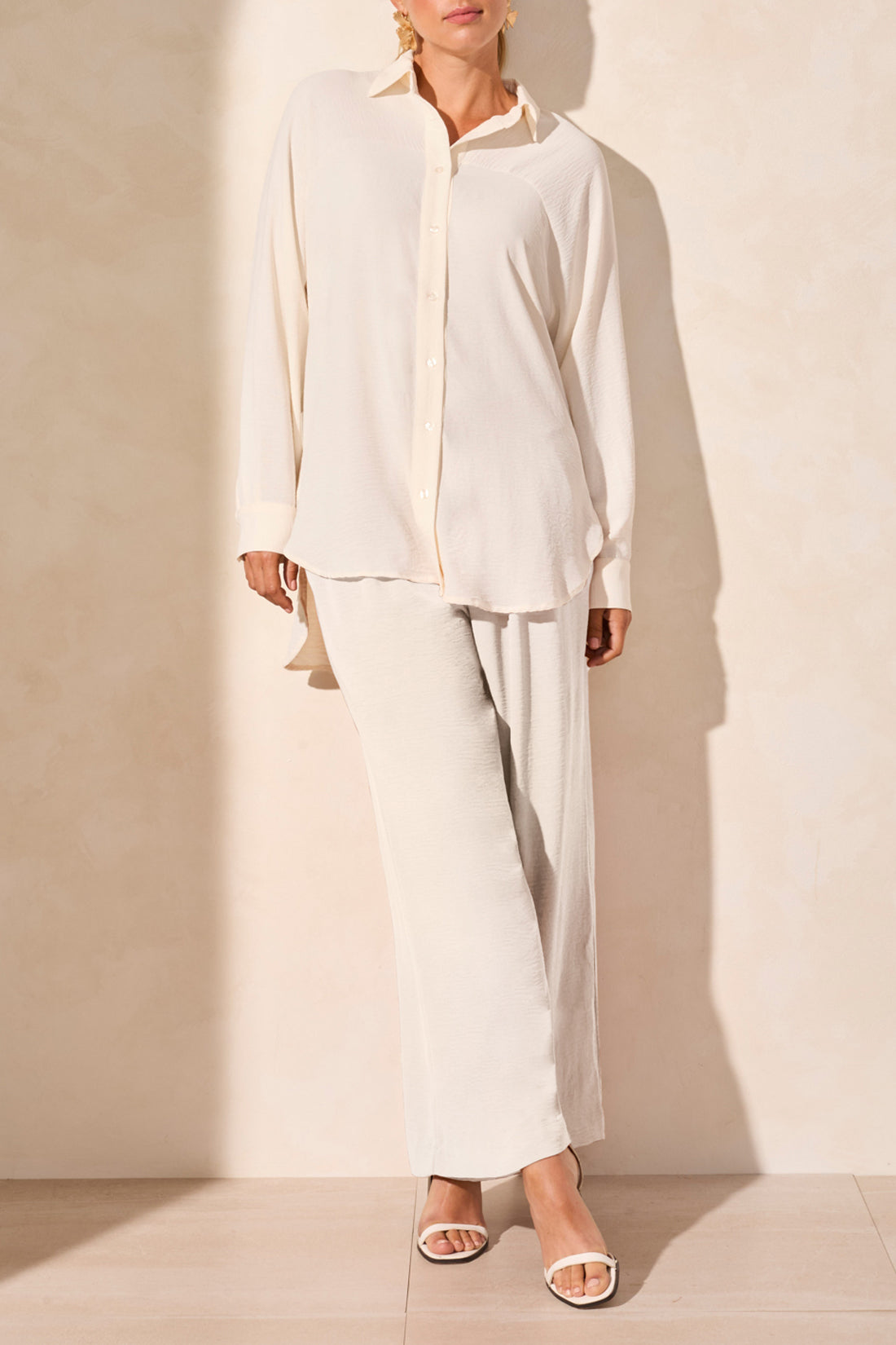 wide leg flowy pants in off hite and matching shirt worn by model