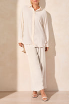 wide leg flowy pants in off hite and matching shirt worn by model