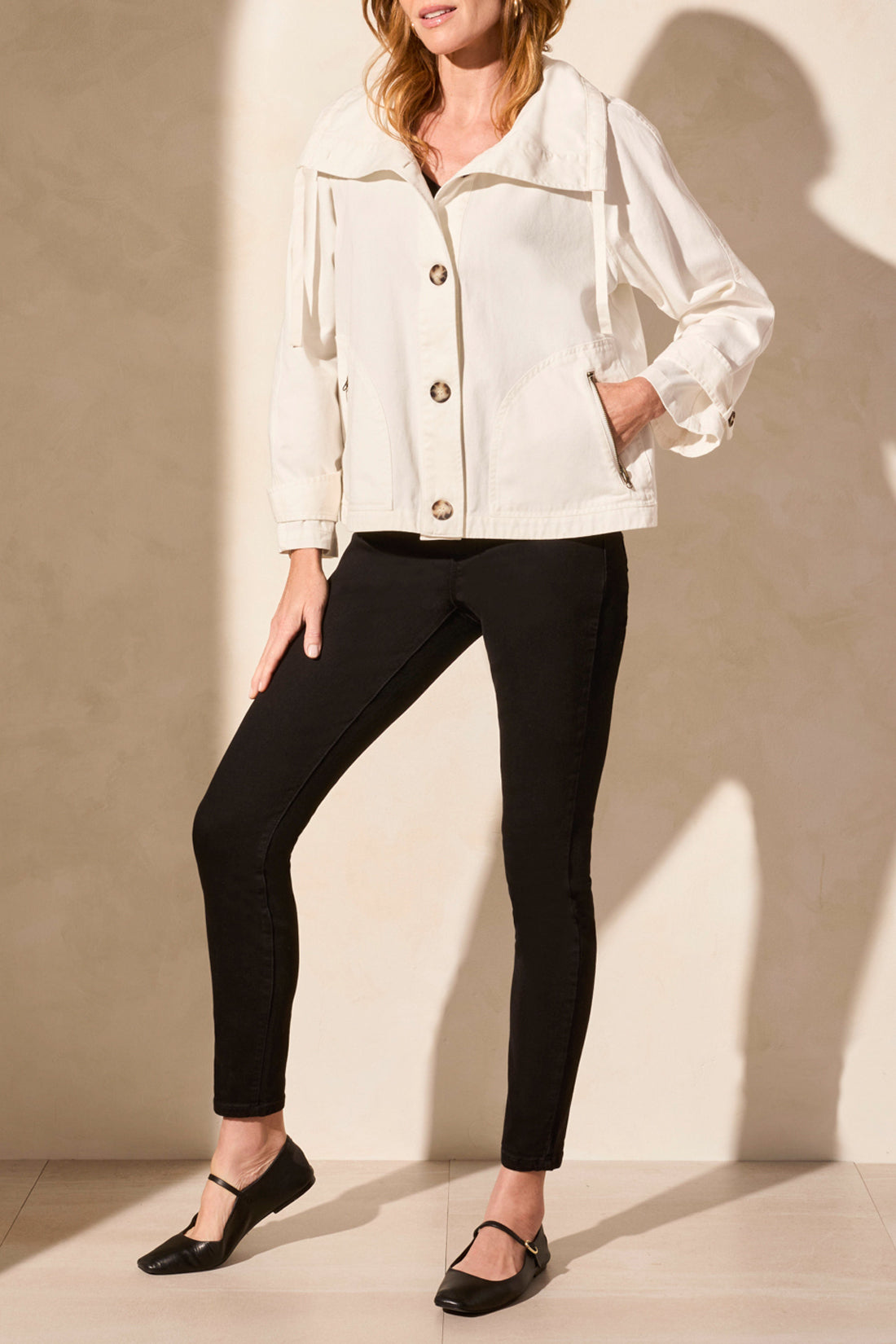 light coat jacket in white with black pants worn by model