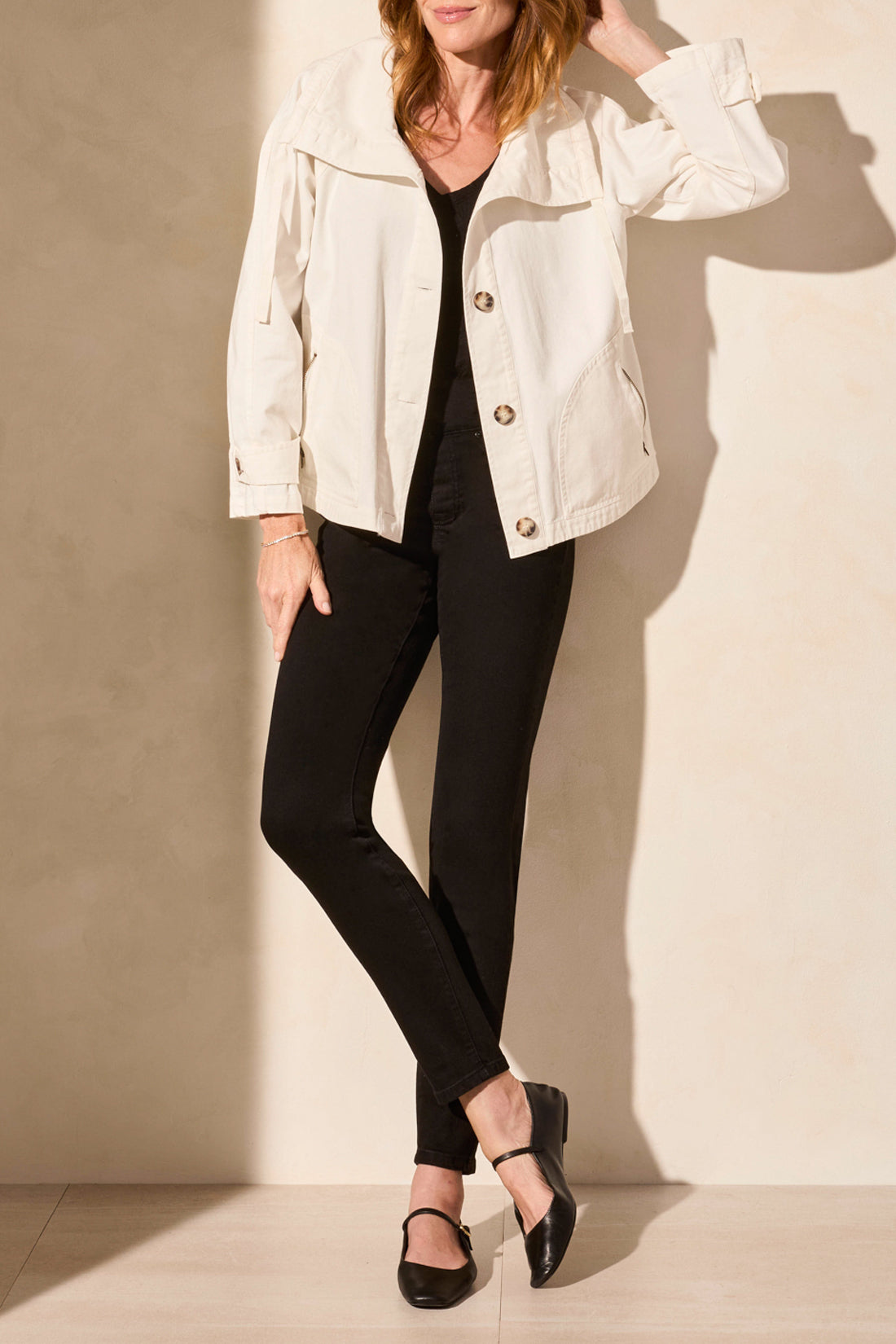 light coat jacket in white un buttoned with black pants worn by model