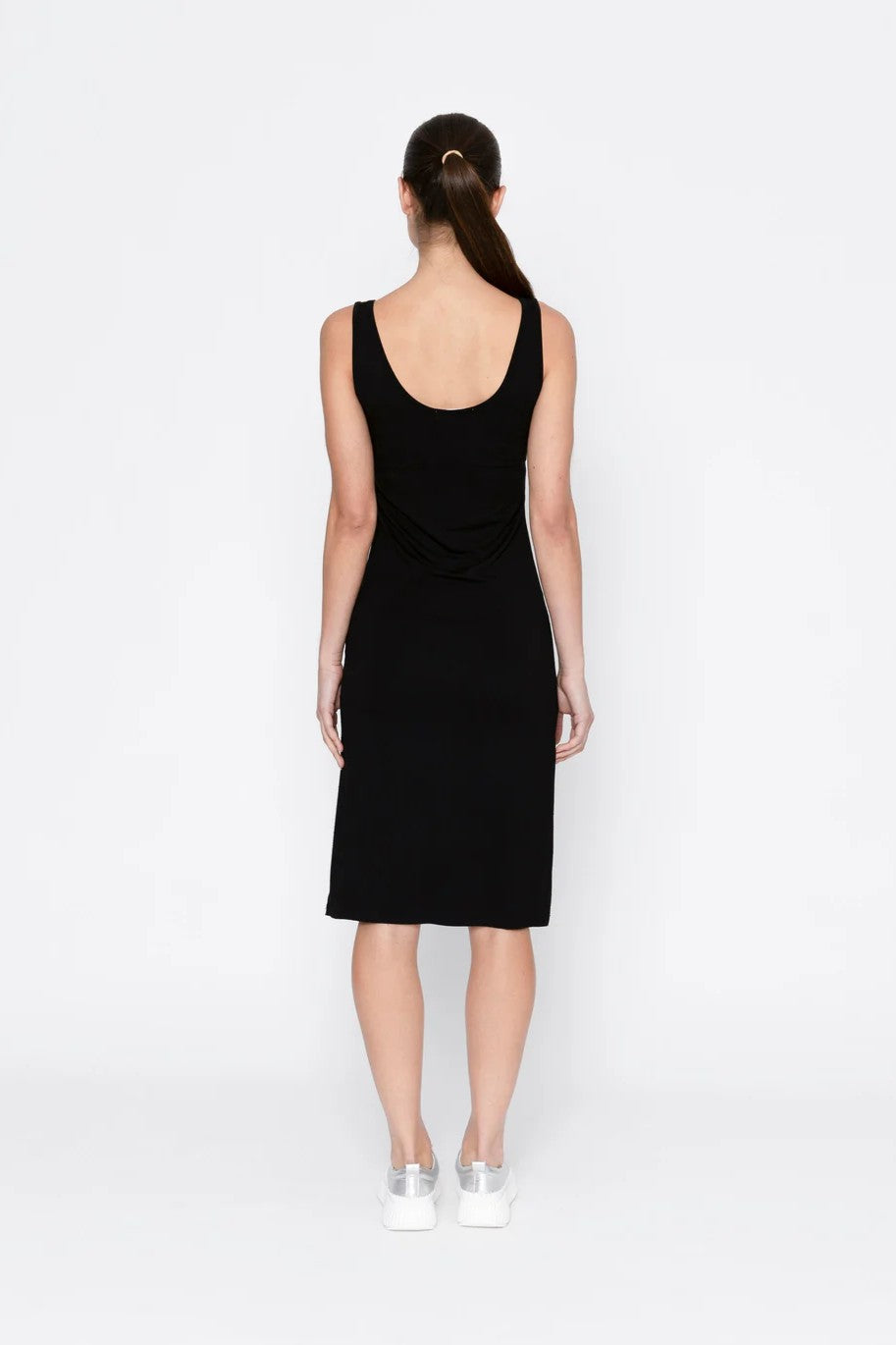 Black sleeveless dress worn by a model on a white background back angle