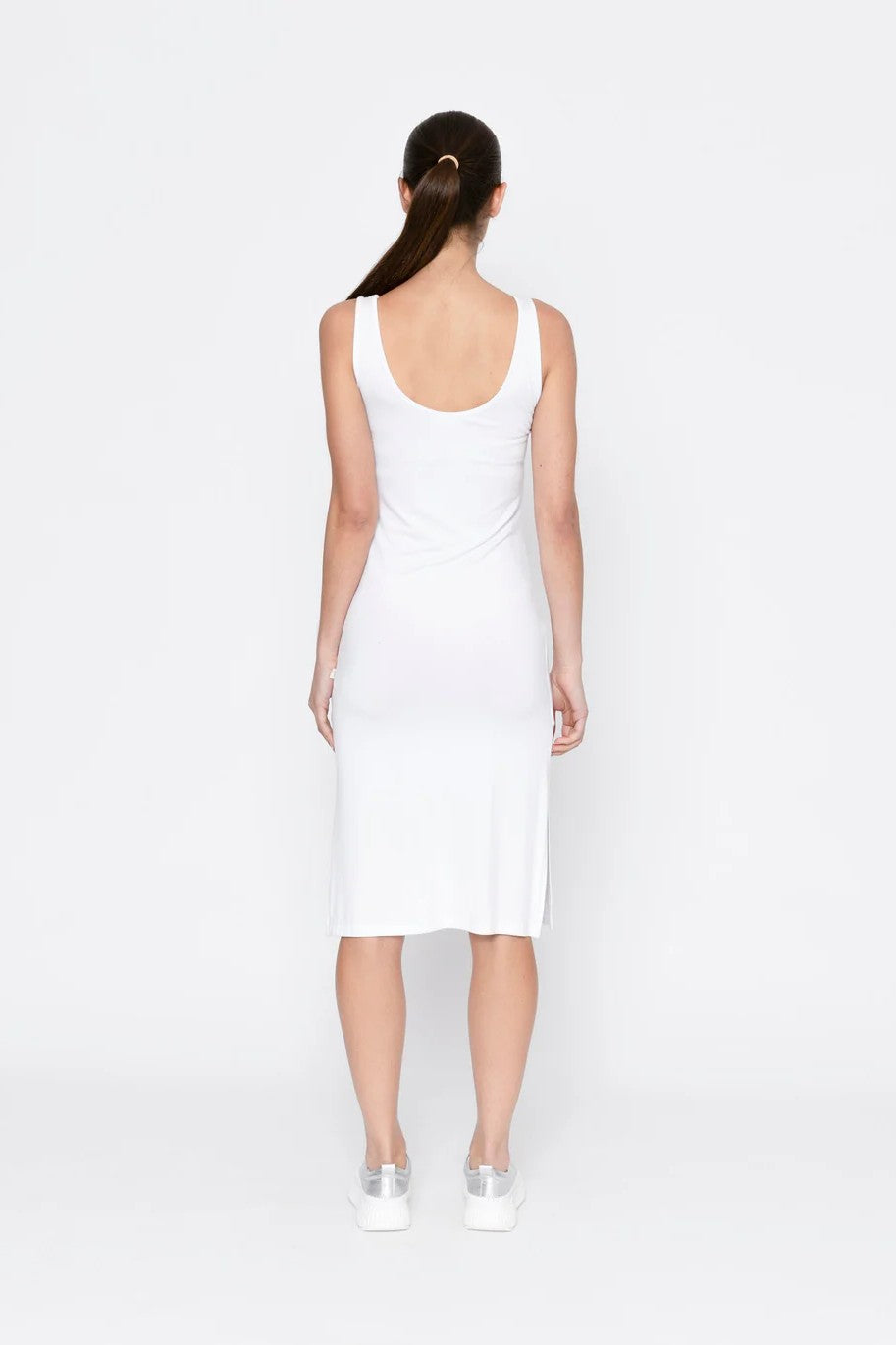 Woman wearing a white sleeveless dress on a white background back angle