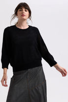 model wearing black sweater with heart sleeves 