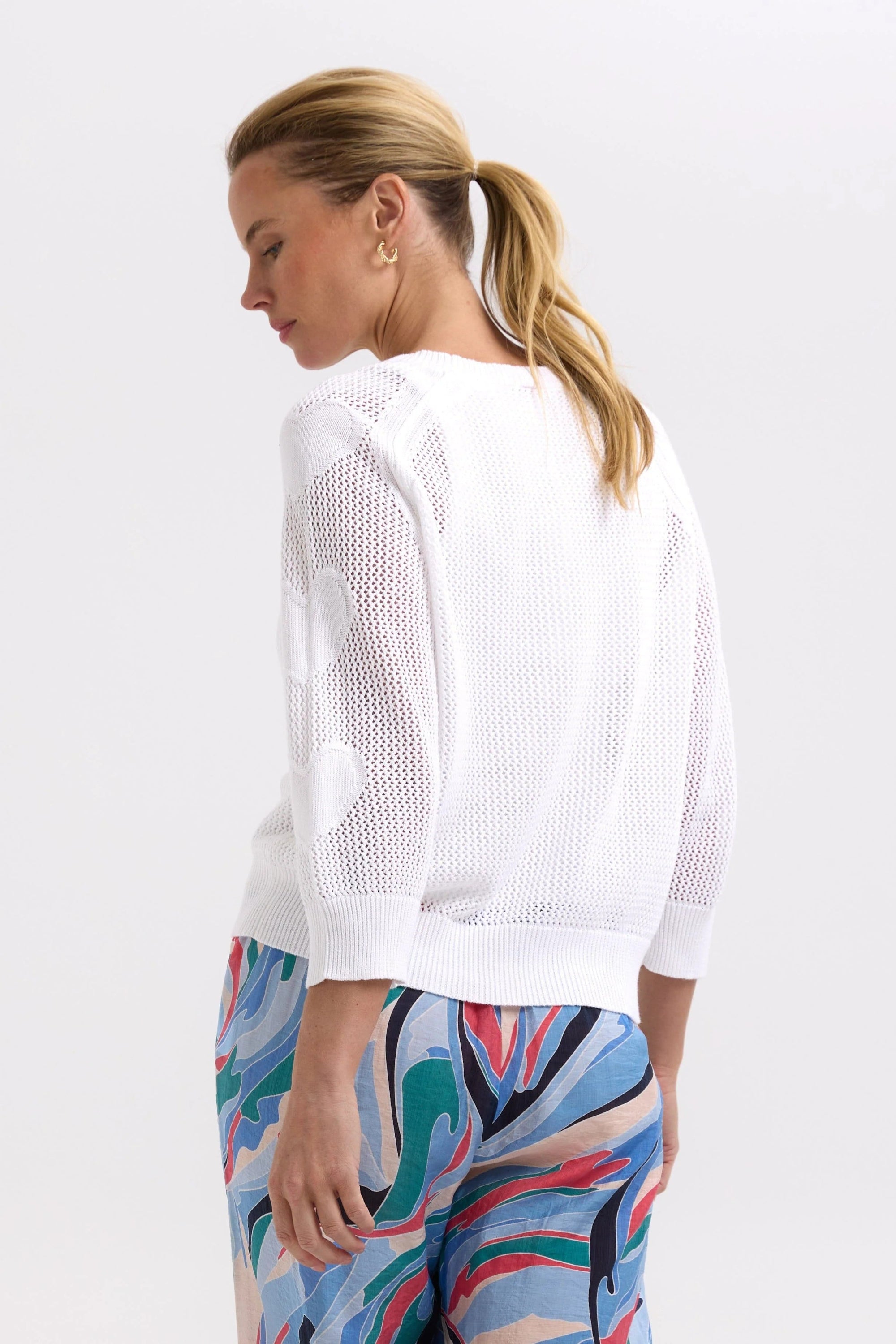 model wearing white sweater with heart sleeves back 