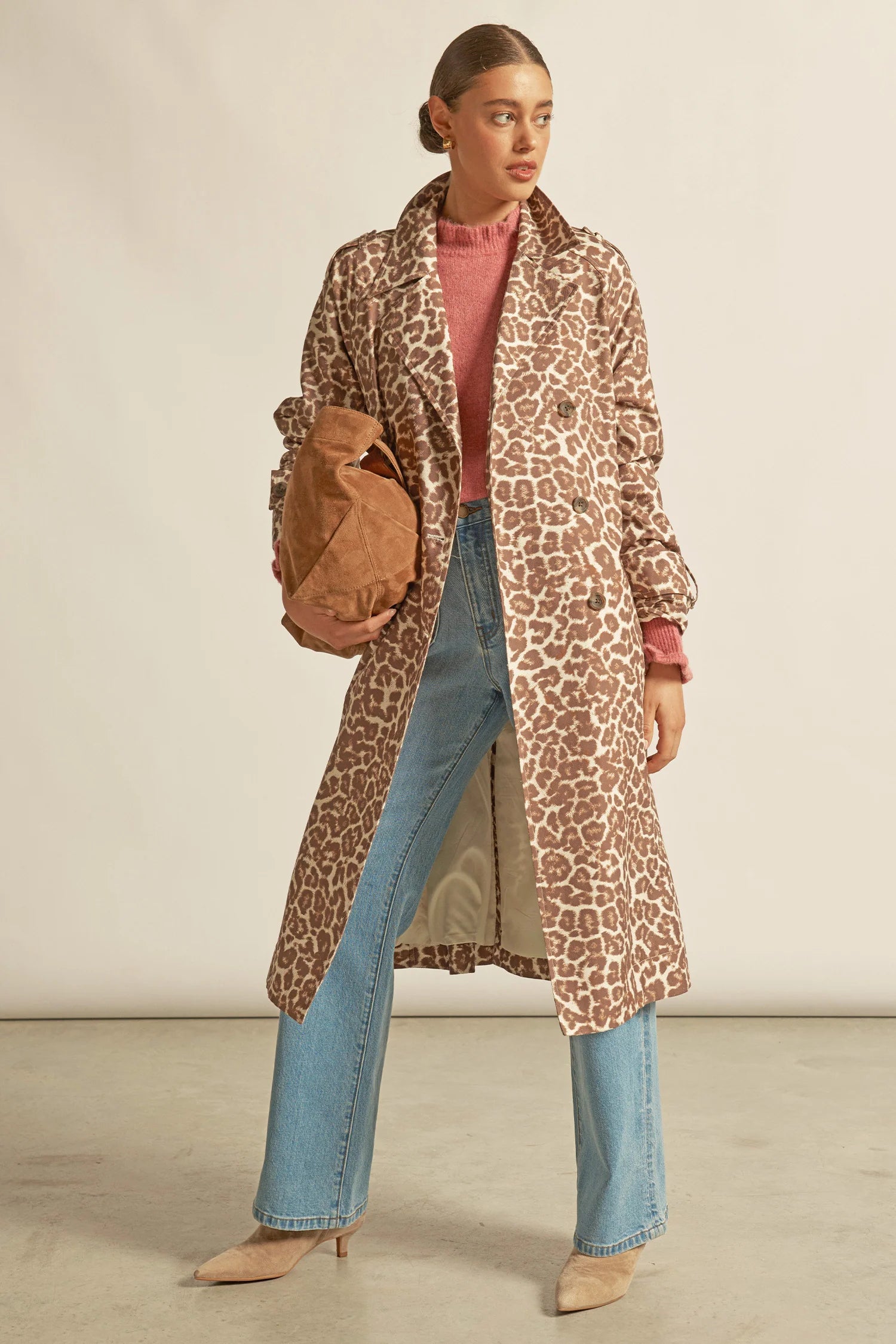 Woman wearing a leopard print coat with a plain background