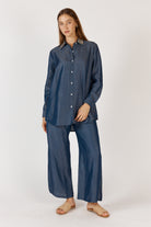 Women wearing a denim shirt and pant set on a white background