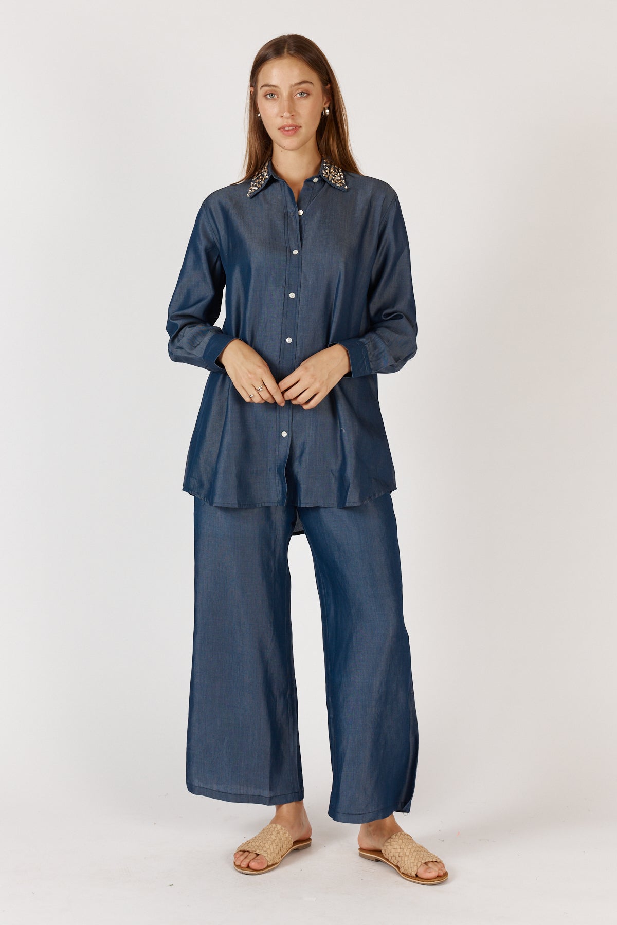 Women wearing a denim shirt and pant set on a white background