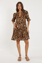 Woman wearing a leopard print dress on a white background