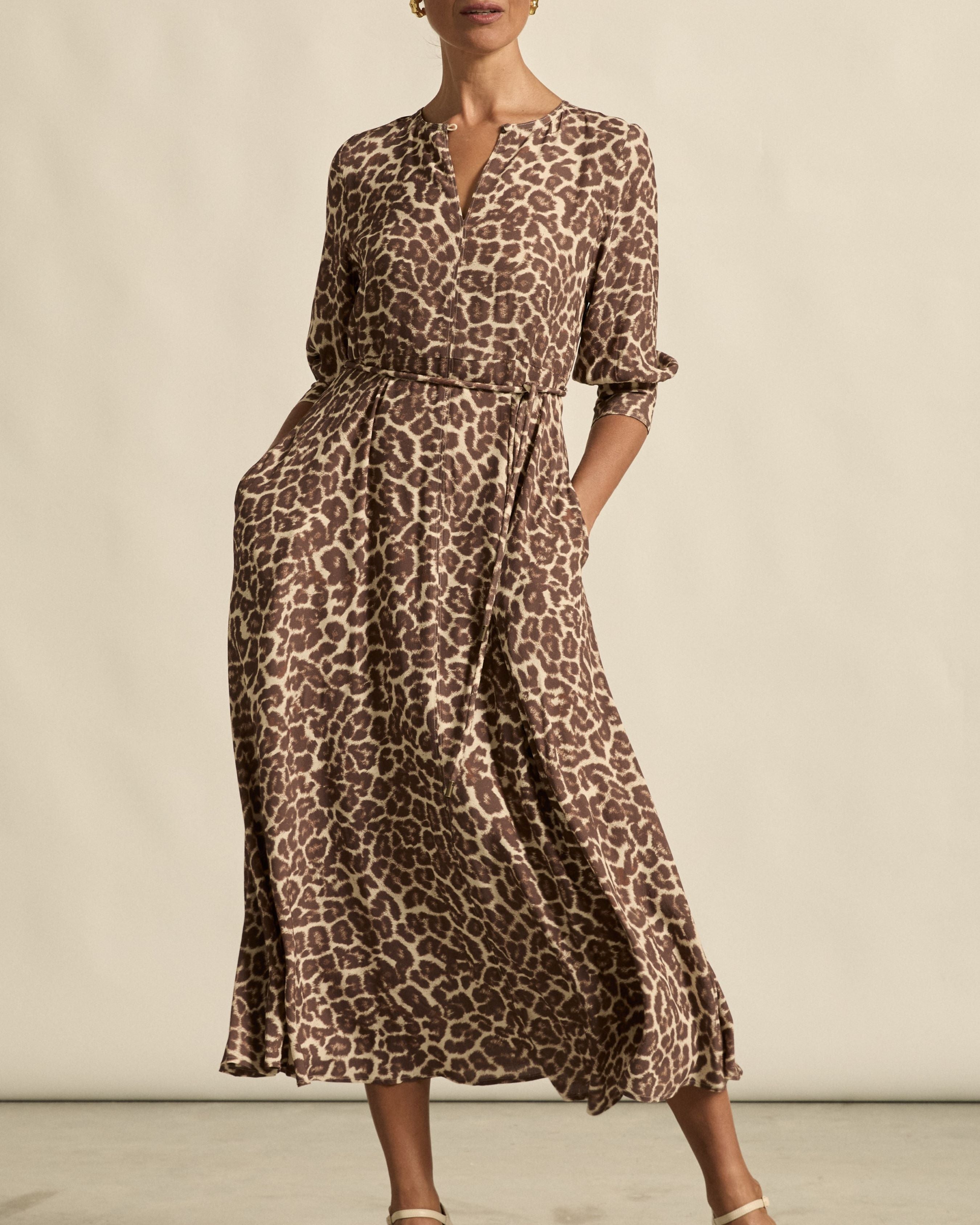 Woman wearing a leopard print dress against a neutral background