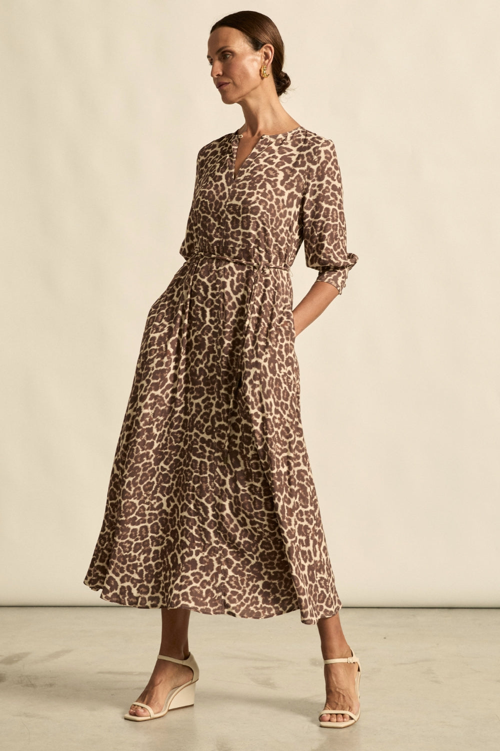 Woman wearing a leopard print dress against a neutral background