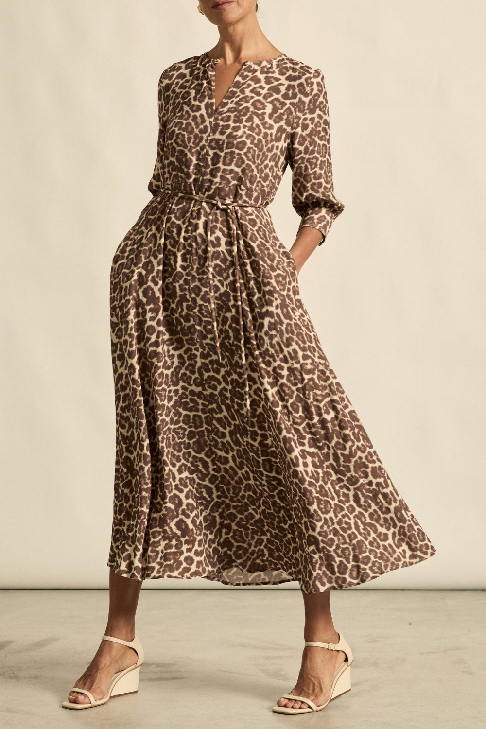 Woman wearing a leopard print dress against a neutral background