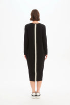 Person wearing a black dress with a white zipper on a white background
